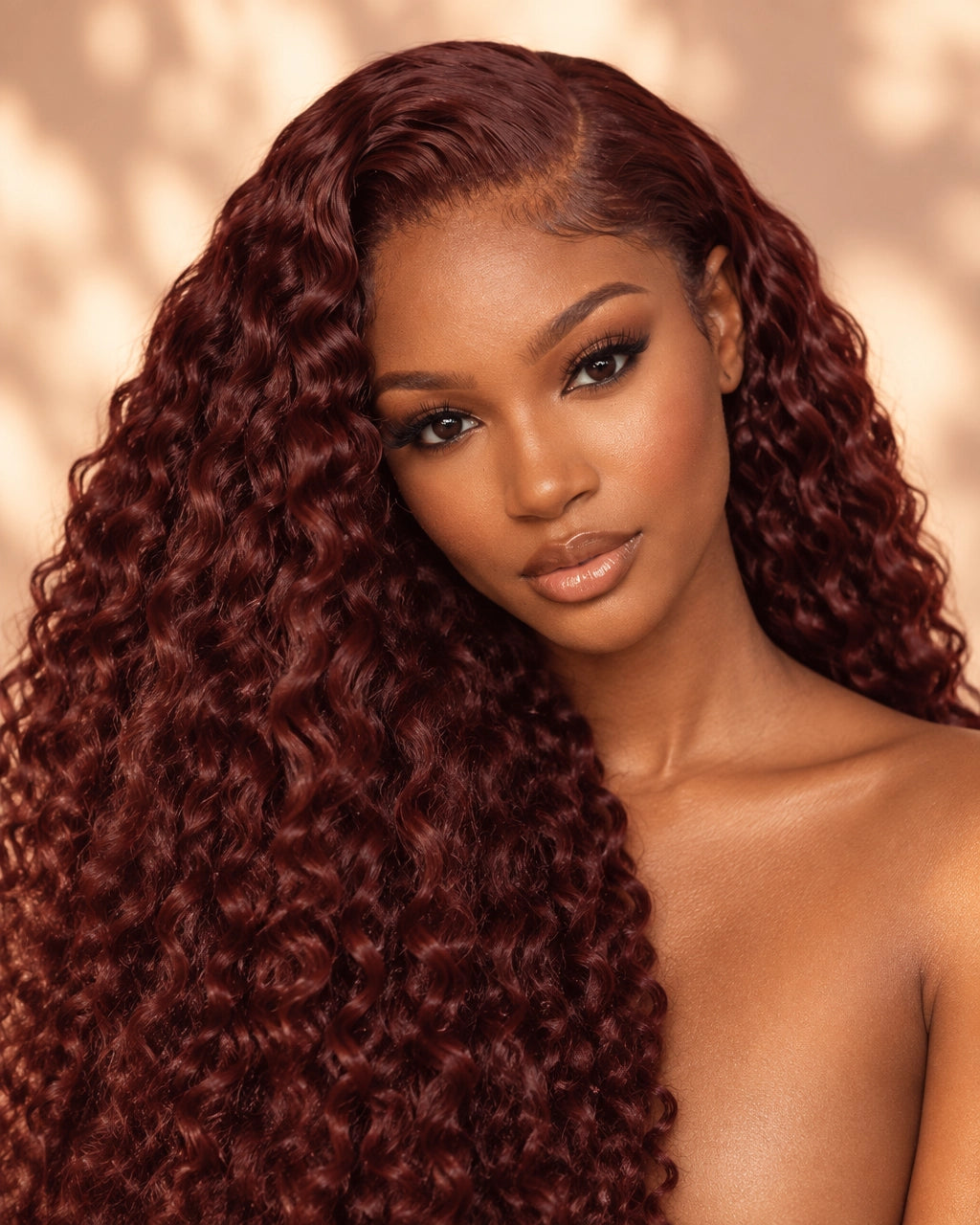 Confident Black woman wearing a rich auburn deep-wave wig in warm autumn light